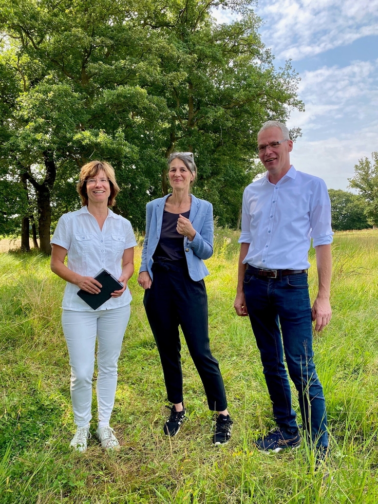 Miriam Staudte, Susanne Gerstner und Hubertus Berges stehen auf einer grünen Wiese